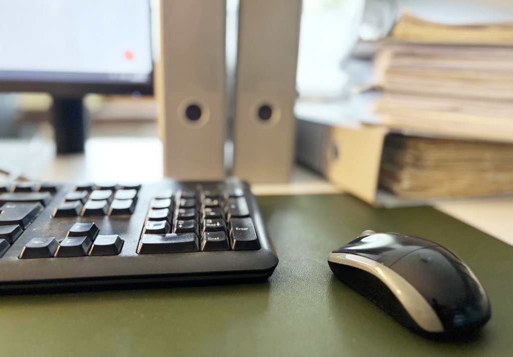 Schreibtisch mit Computer und Ordnern